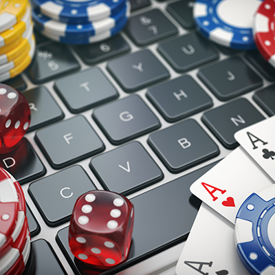 Computer keyboard with poker chips, dice and playing cards